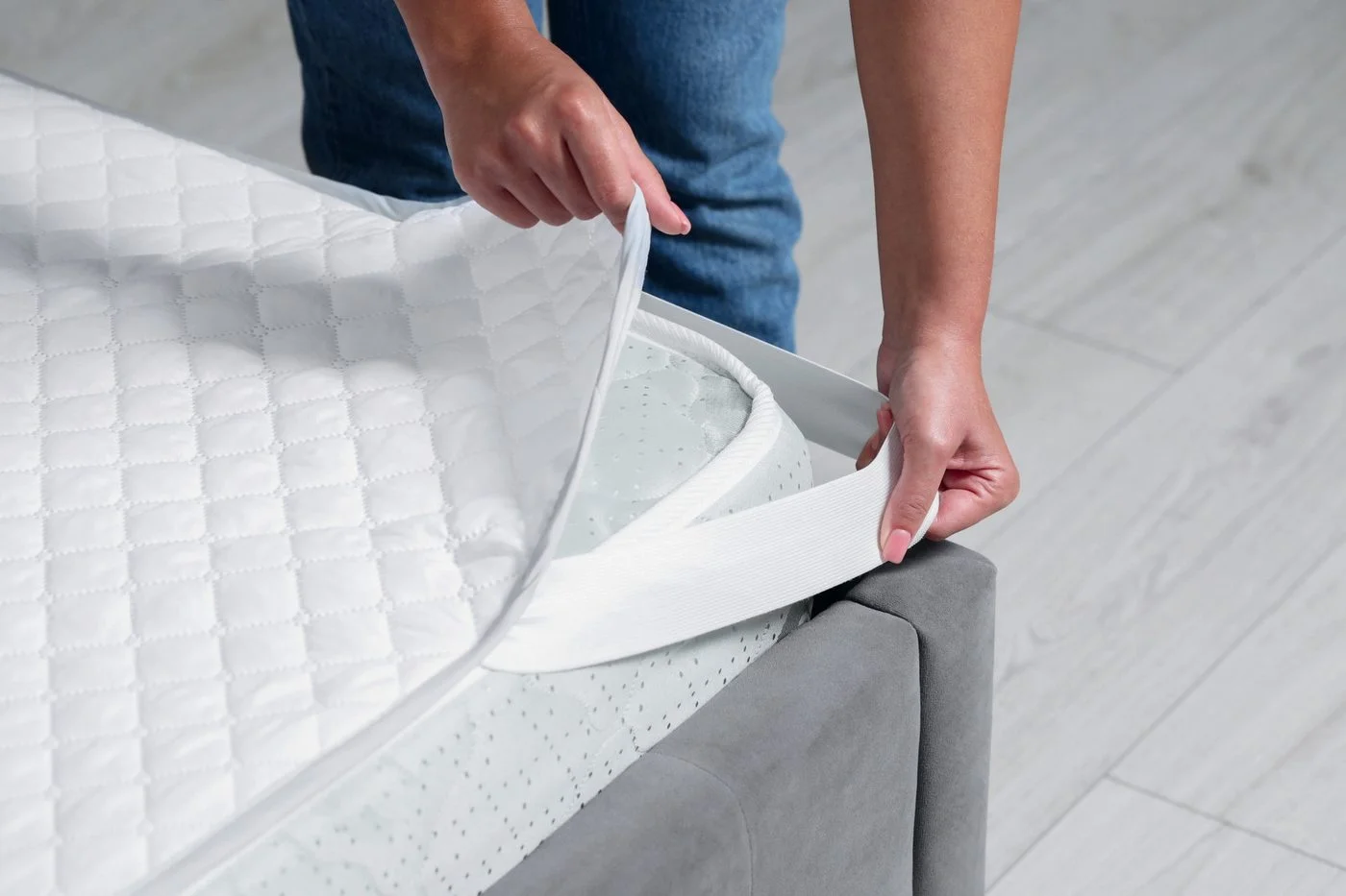 Fitting a mattress protector onto a bed