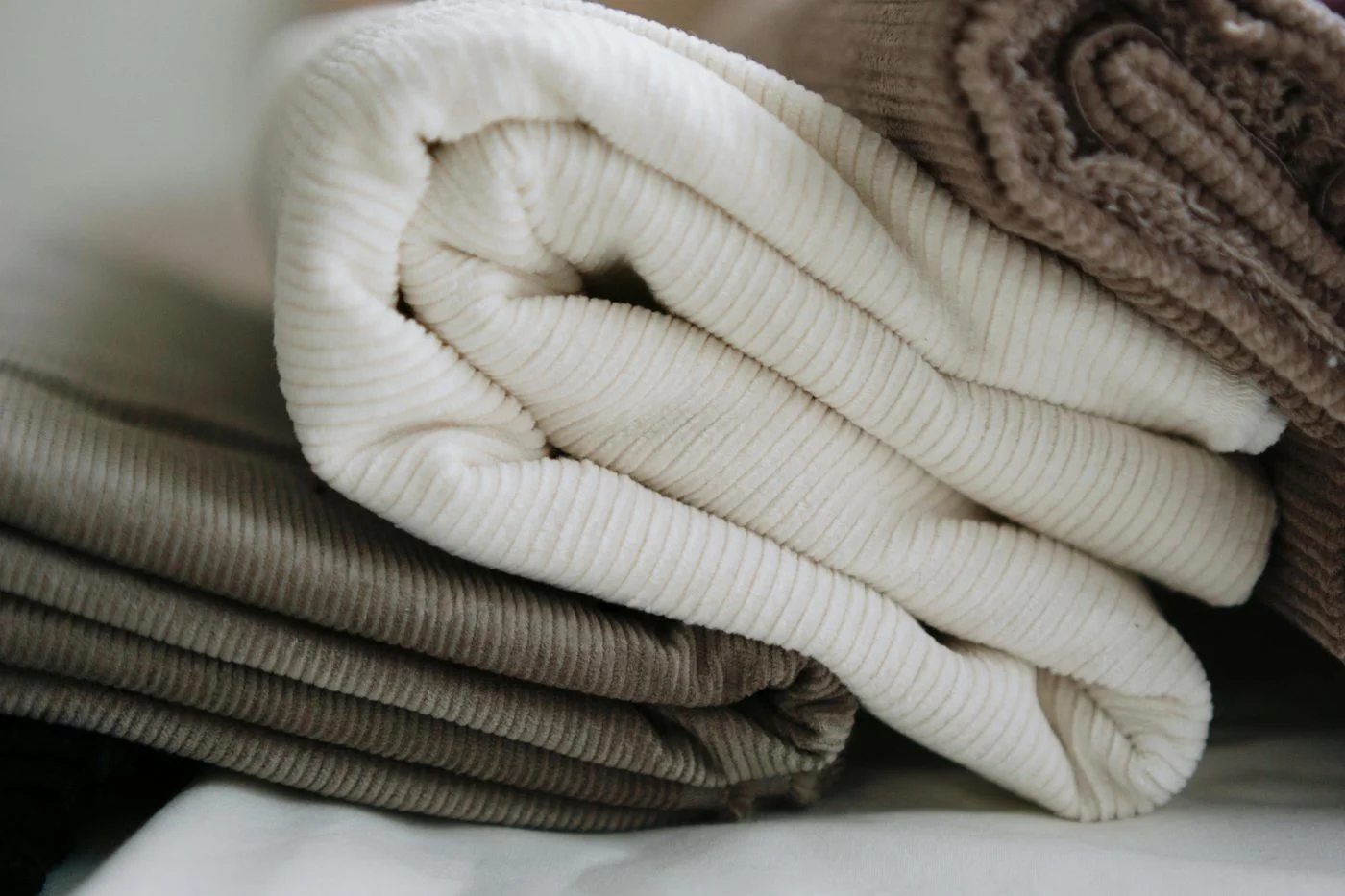 Folded stack of neutral-toned waffle throws and blankets